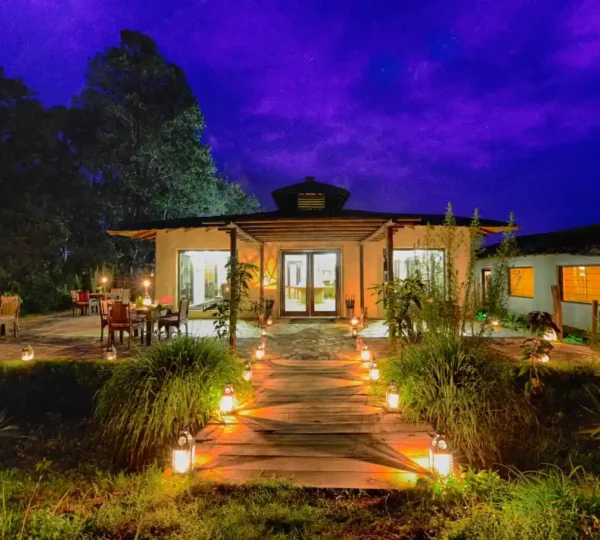 Luxury Resorts in Jim Corbett featuring a beautifully illuminated resort with landscaped gardens and elegant outdoor seating for a premium forest retreat.