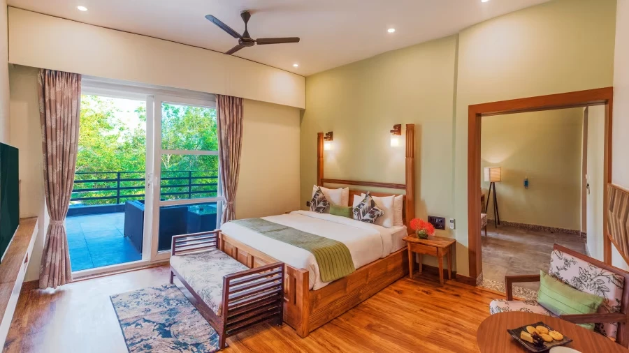 Best resorts in Jim Corbett showcasing a deluxe room with a private balcony, spacious interiors, and scenic nature views.