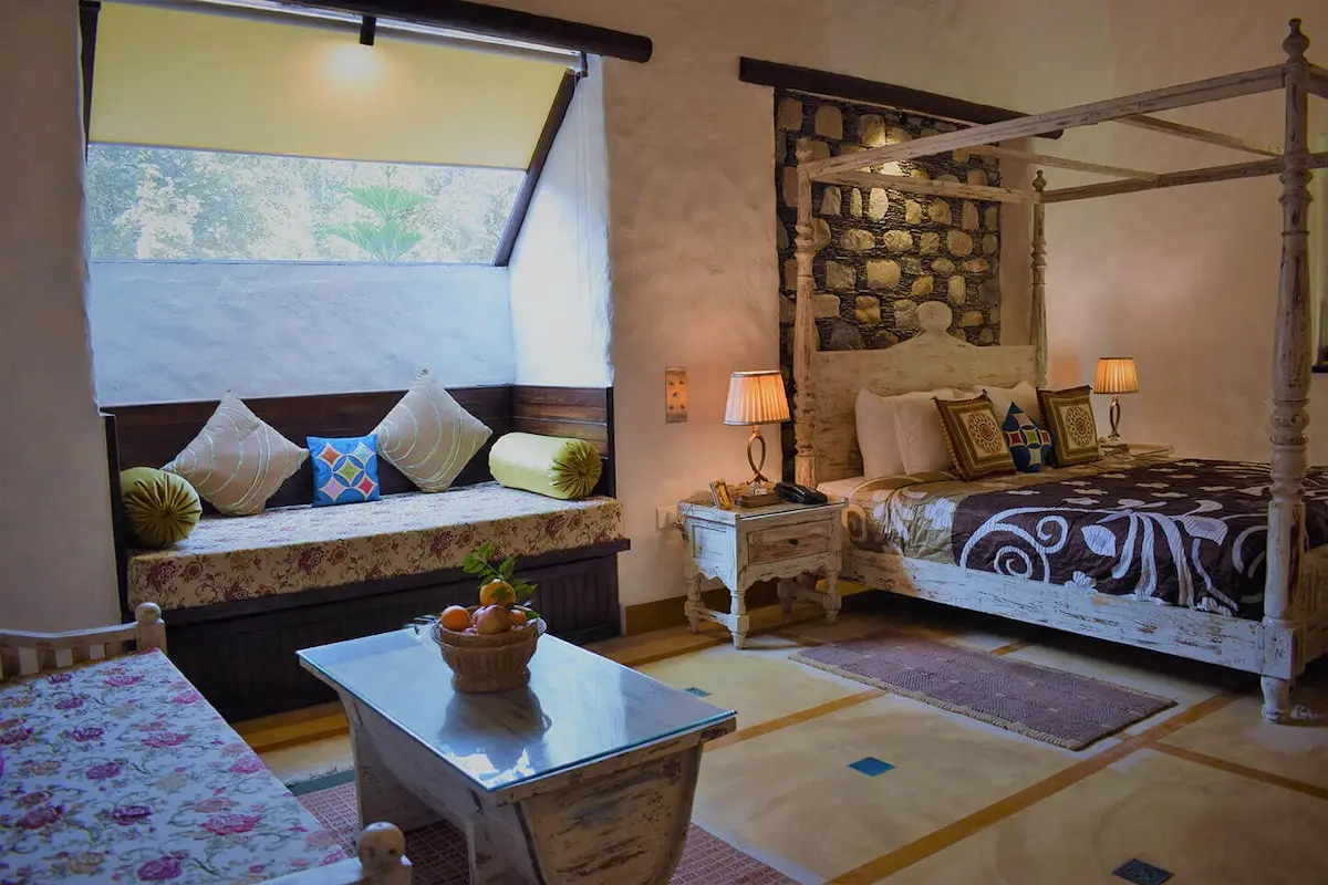 Best resorts in Jim Corbett featuring a luxury suite with elegant interiors, king-size bed, and premium amenities for a comfortable wildlife getaway.
