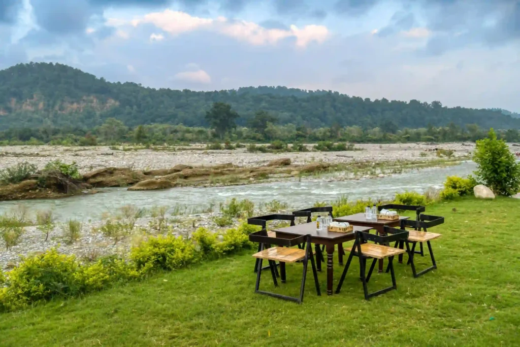 Riverside resorts in Jim Corbett with outdoor dining beside the river, panoramic mountain views, and a tranquil setting for memorable meals in nature.